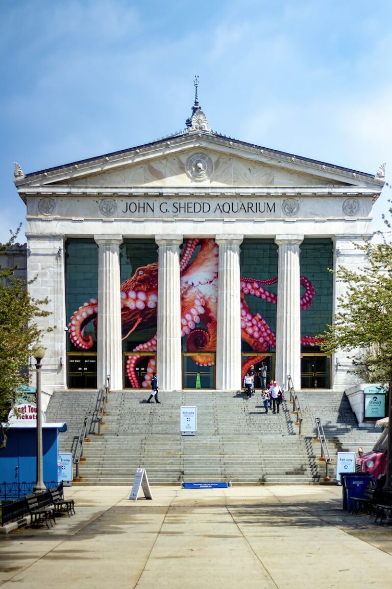 a large building with columns and a mural on the side of it